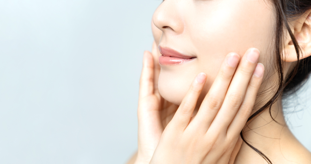 Young woman smiling confidently after dental treatment for bruxism relief